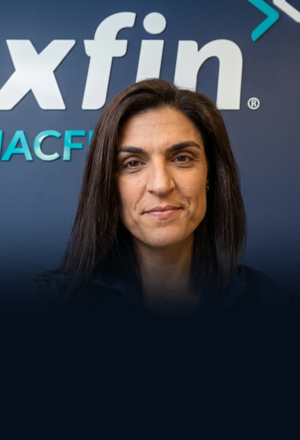Responsável da XFIN MACFIN, com o logótipo da empresa na parede
