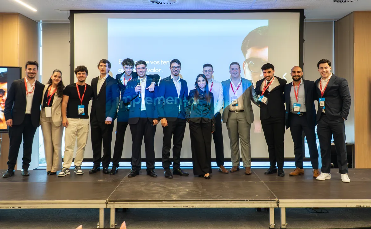 A equipa da BoomLab em palco no fecho de uma sessão, com a palavra Implementar projetada no ecrã